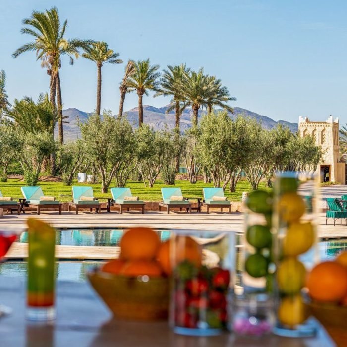 Vue sur la piscine bordée de palmiers de Lumaya Garden